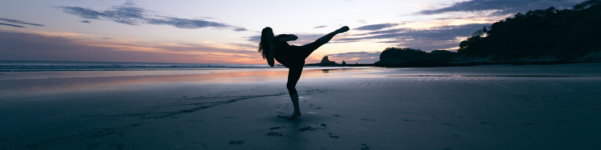 Silhouetted karate kick on the beach