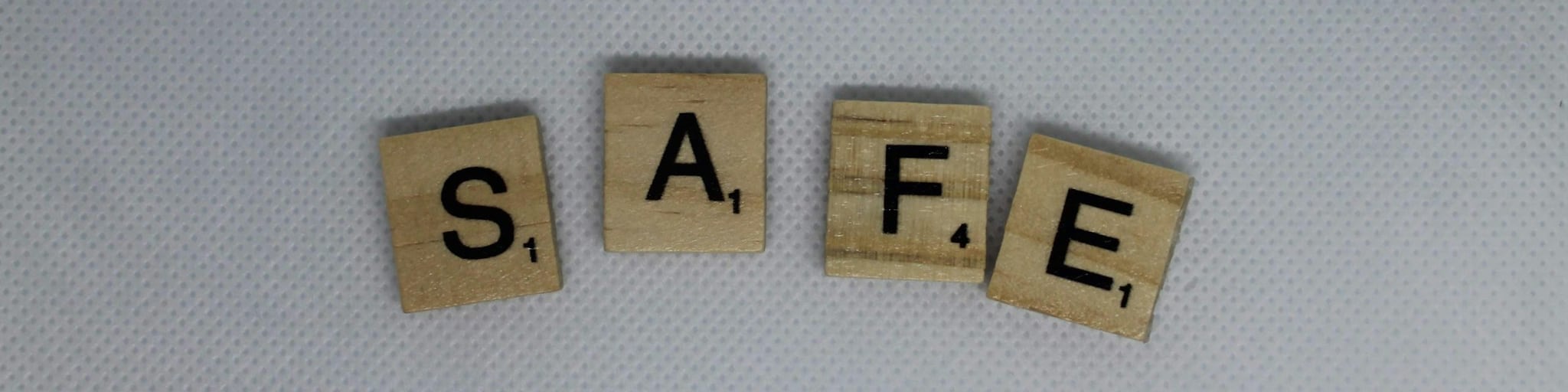 Wooden Scrabble pieces spelling SAFE